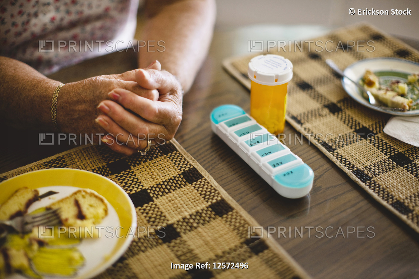 Senior woman with pill case on table