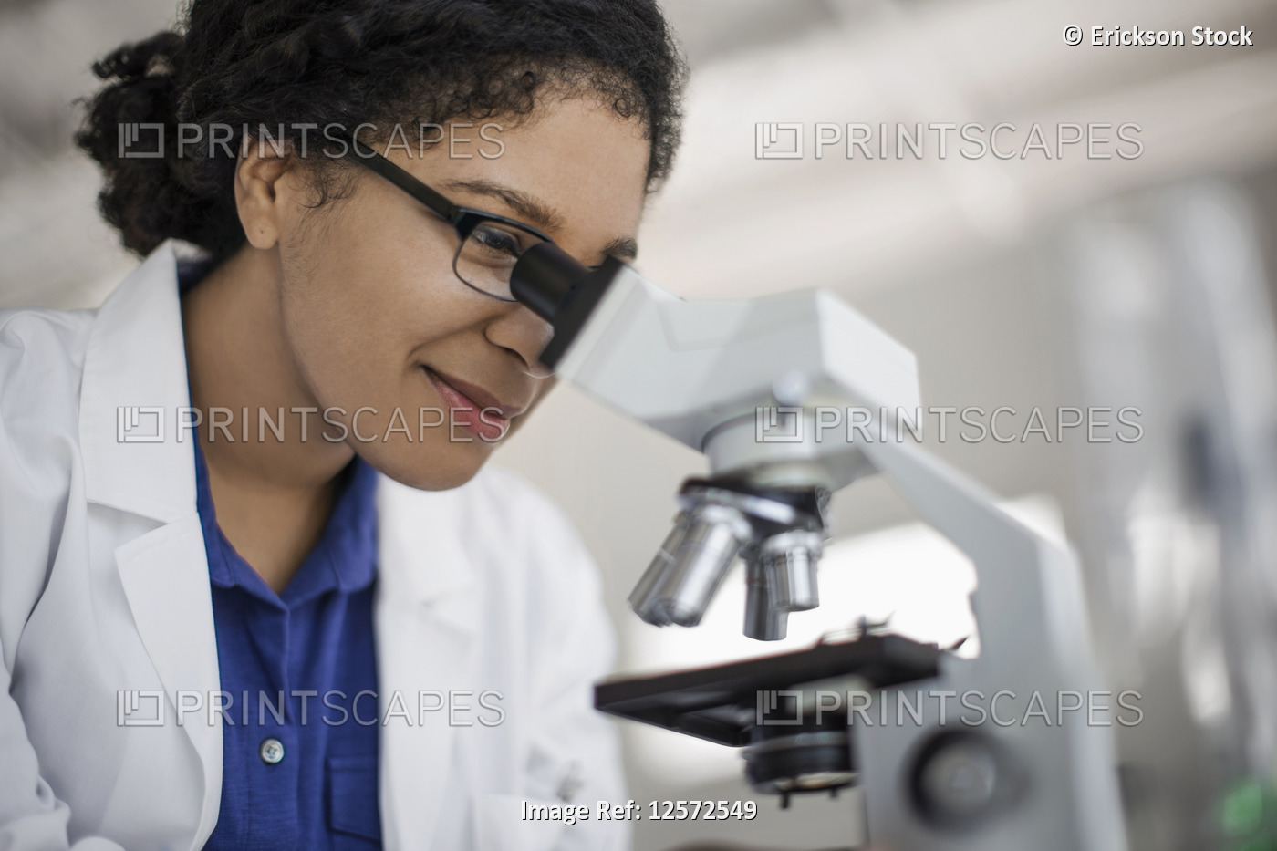 Scientist examining a sample through a microscope