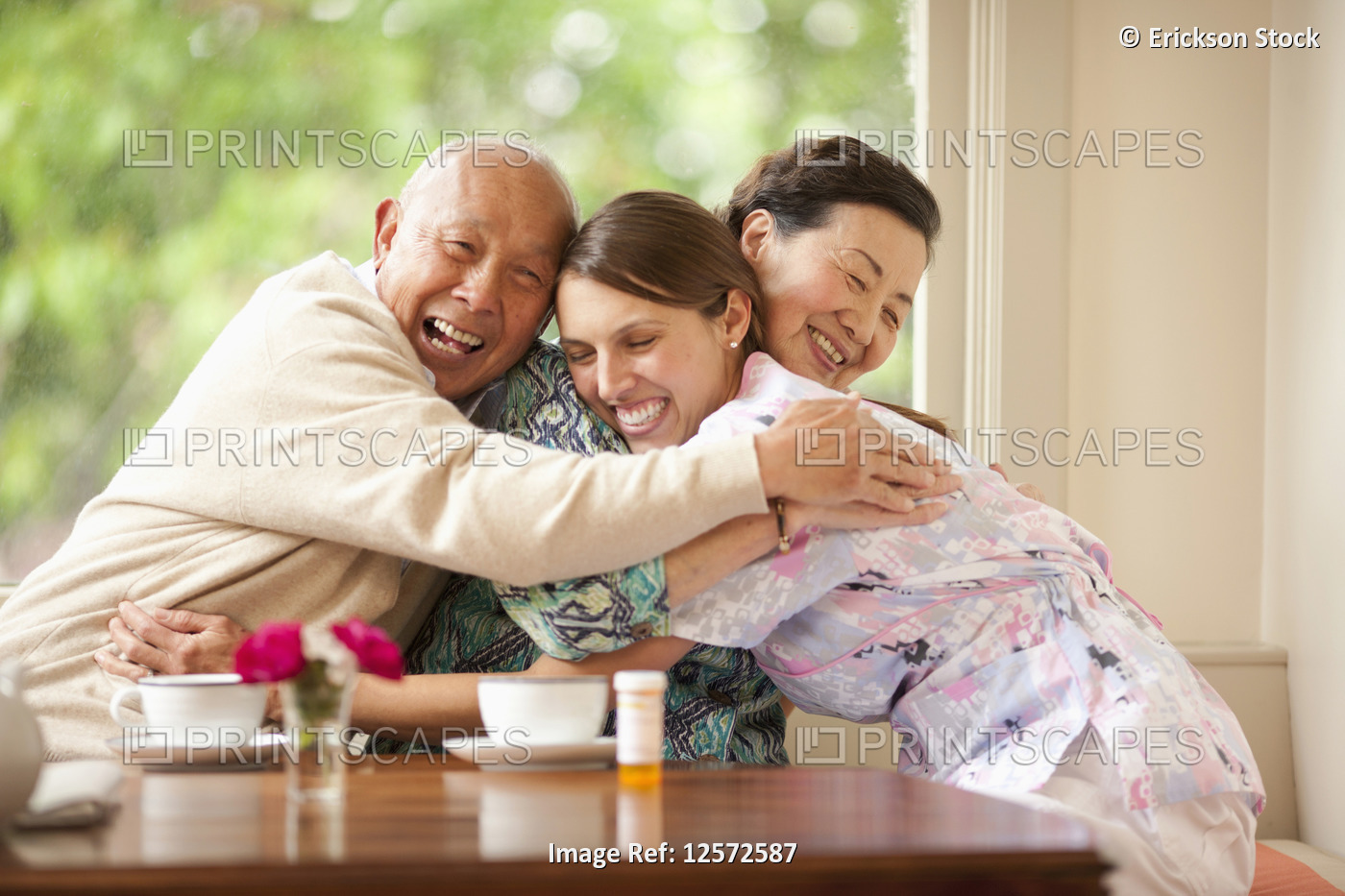 Senior couple hugging their nurse