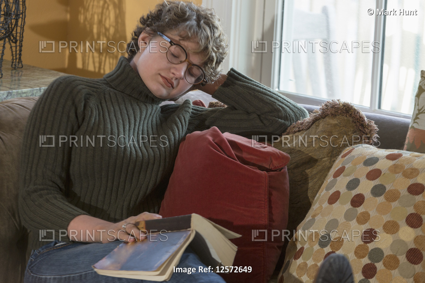 Woman with Sjogren-Larsson Syndrome resting on sofa while reading a novel