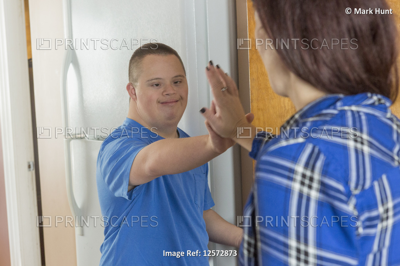Teen boy who has Down Syndrome standing with his friend