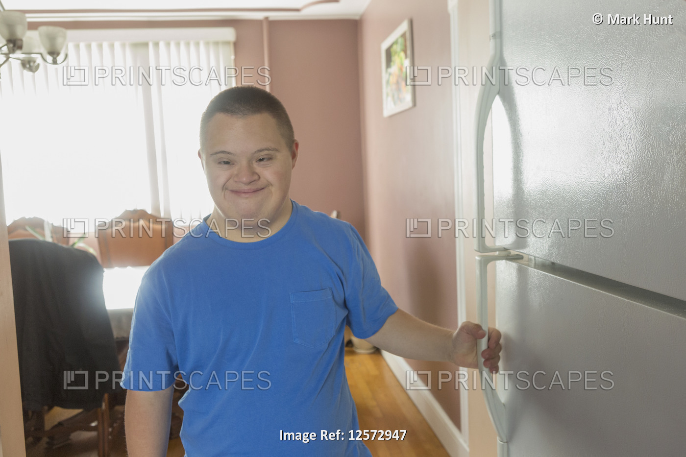 Teen boy with Down Syndrome opening refrigerator