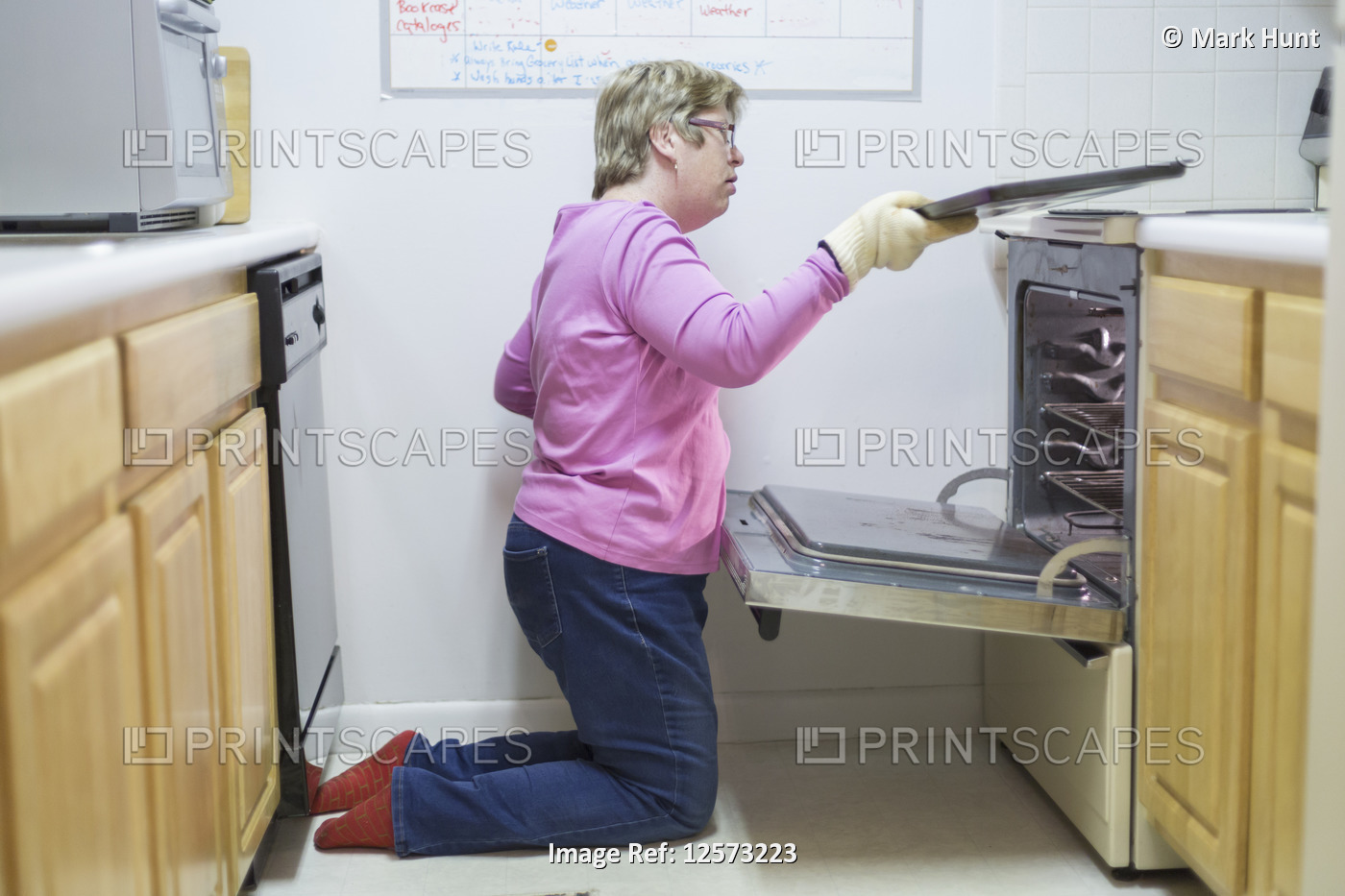 Woman with Autism removing tray from oven