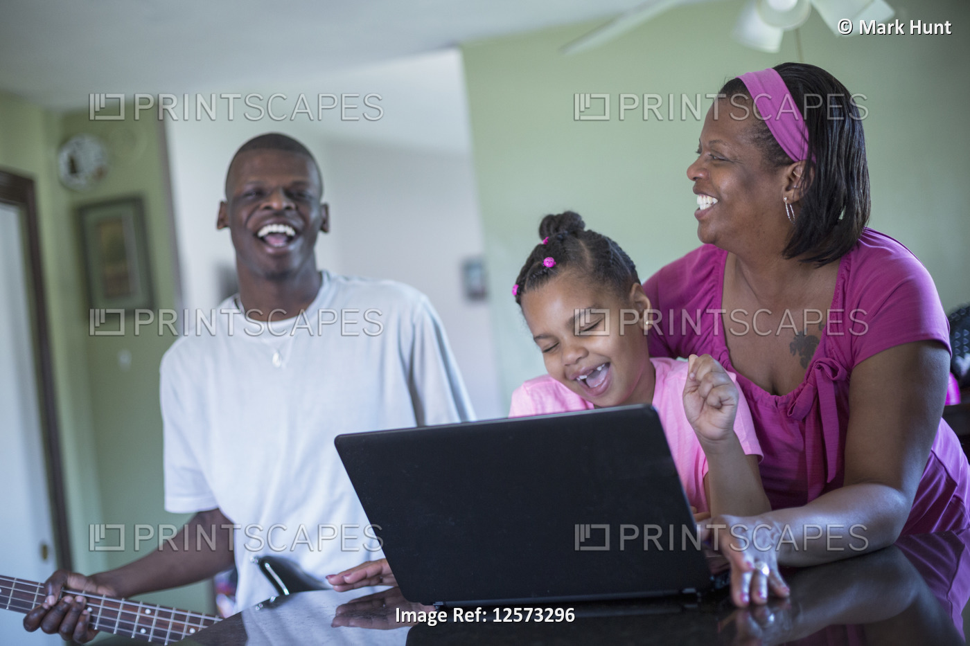 Man with Williams Syndrome playing a guitar and family laughing