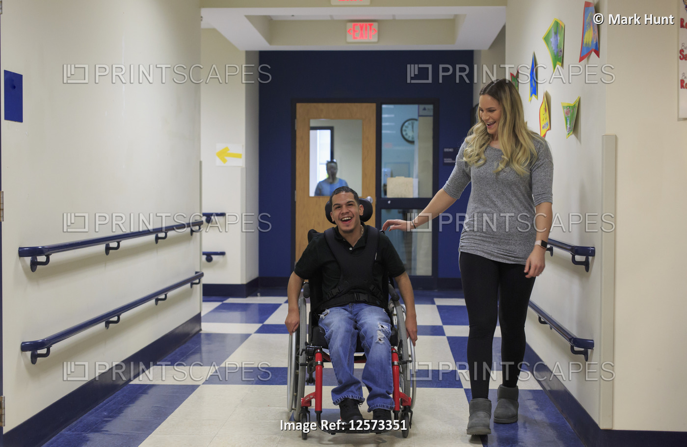 Boy with Spastic Quadriplegic Cerebral Palsy walking down hall at school with ...