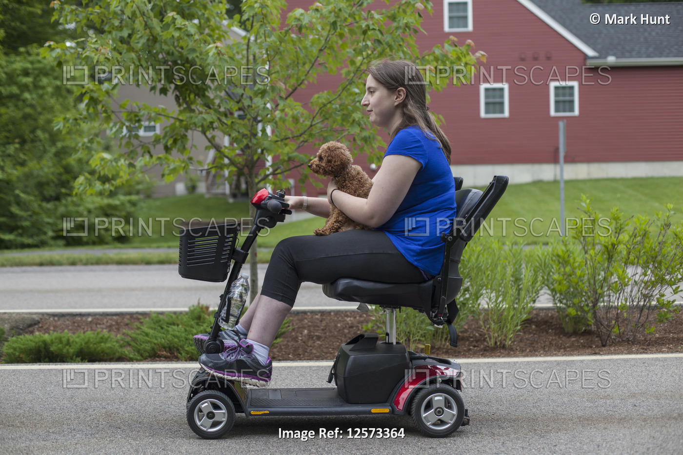 Young Woman with Cerebral Palsy riding the scooter with her dog