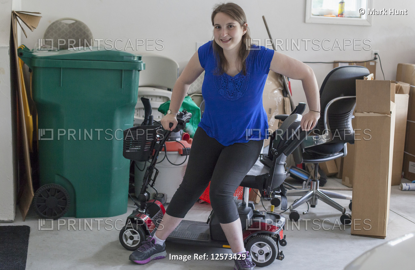 Young Woman with Cerebral Palsy getting into her scooter in the garage