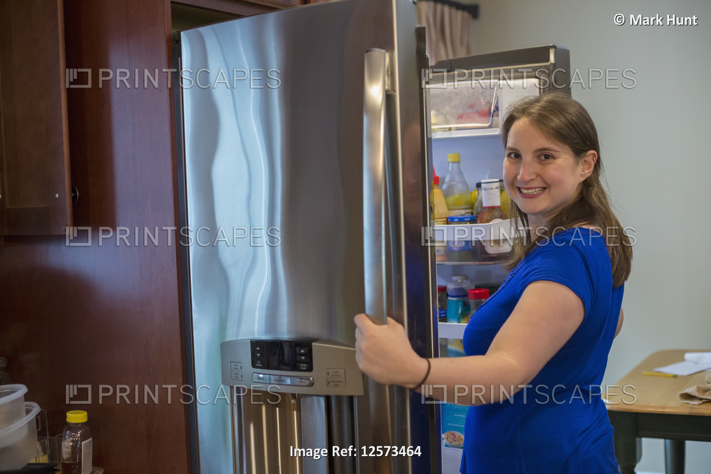 Young Woman with Cerebral Palsy opening refrigerator at home