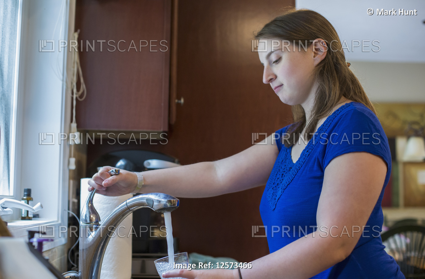 Young Woman with Cerebral Palsy taking a water of glass at home