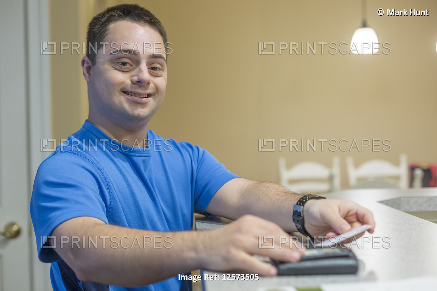 Man with Down Syndrome holding a credit card