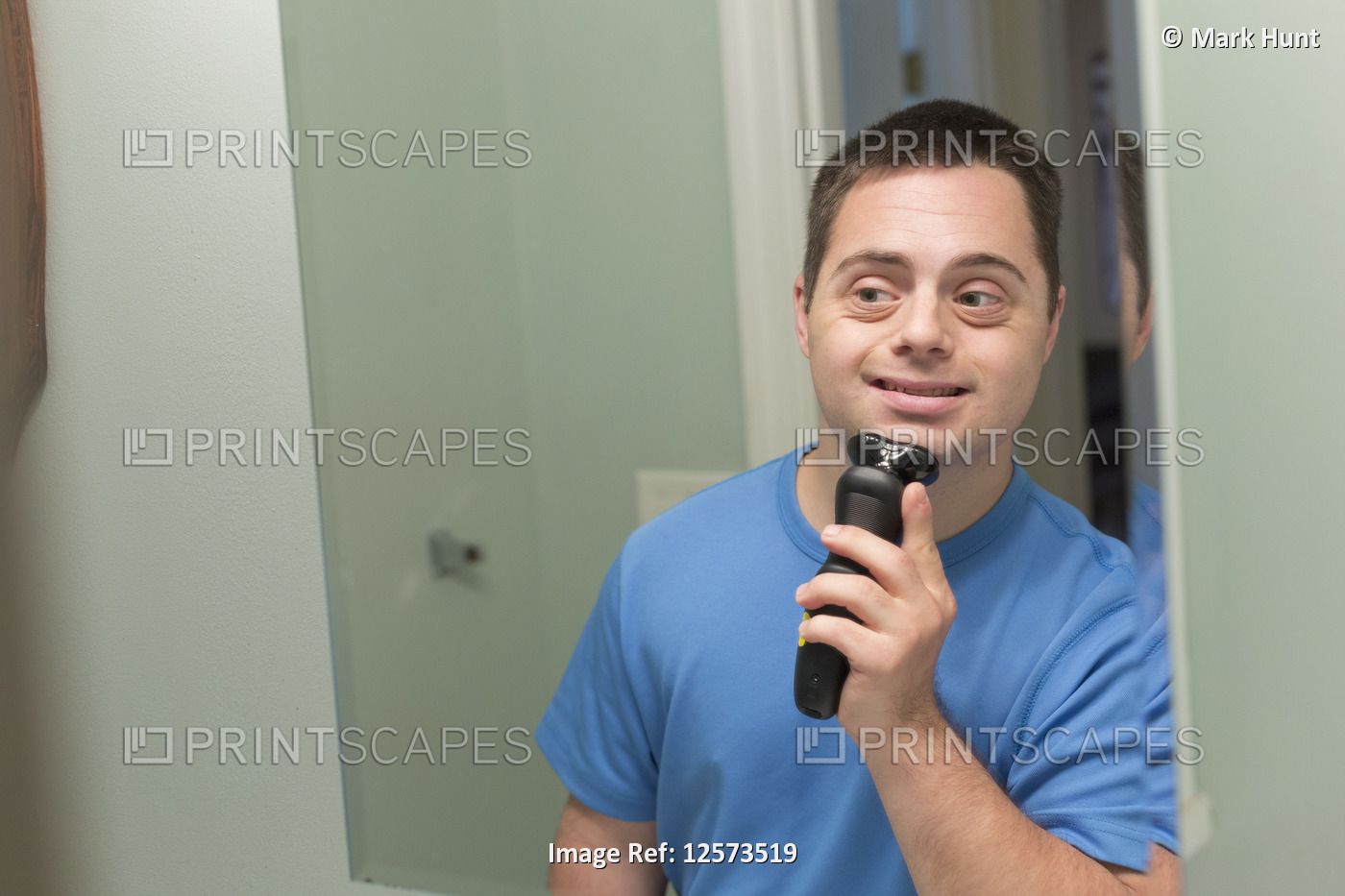 Man with Down Syndrome shaving in bathroom