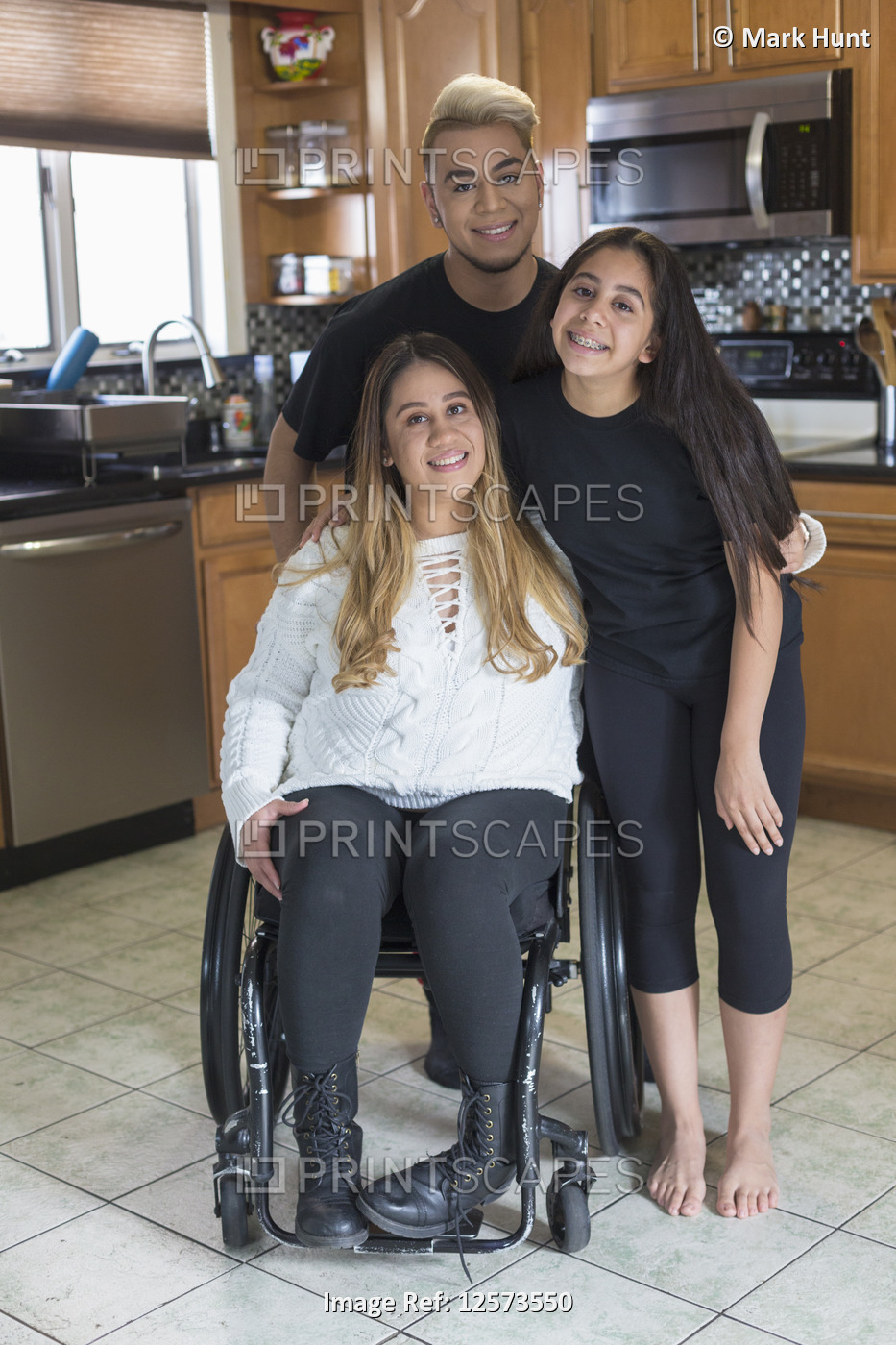 Woman who has Spinal Cord Injury standing with her friends in the kitchen