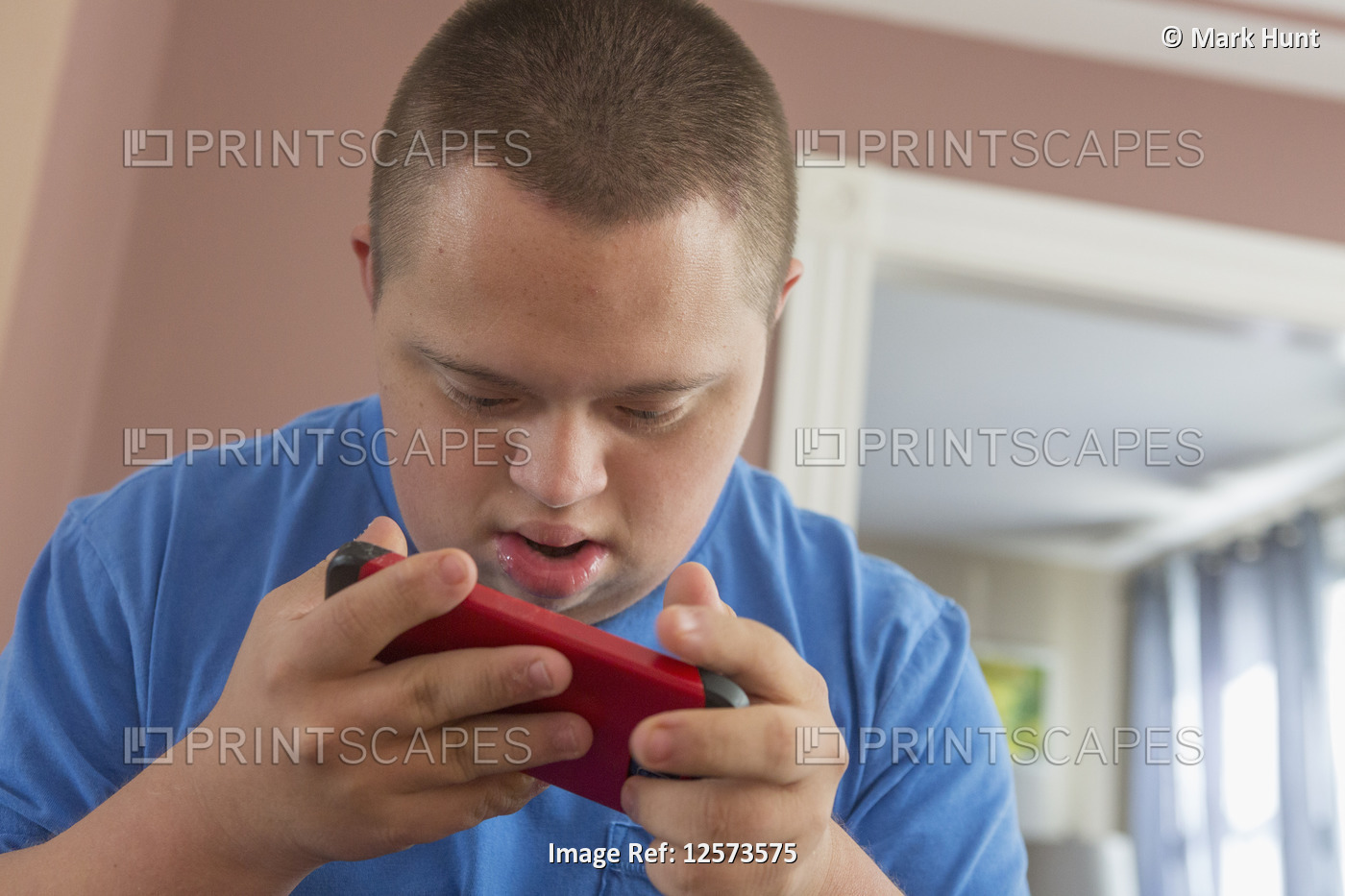 Teen with Down Syndrome holding his phone
