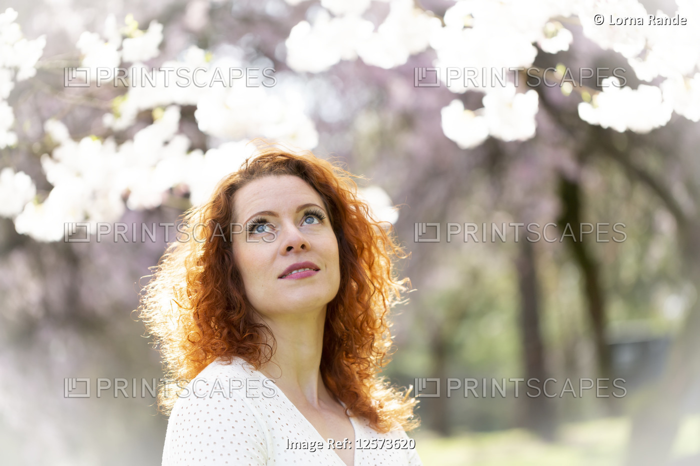 Portrait of a woman with red hair among the cherry blossoms; Vancouver, British ...