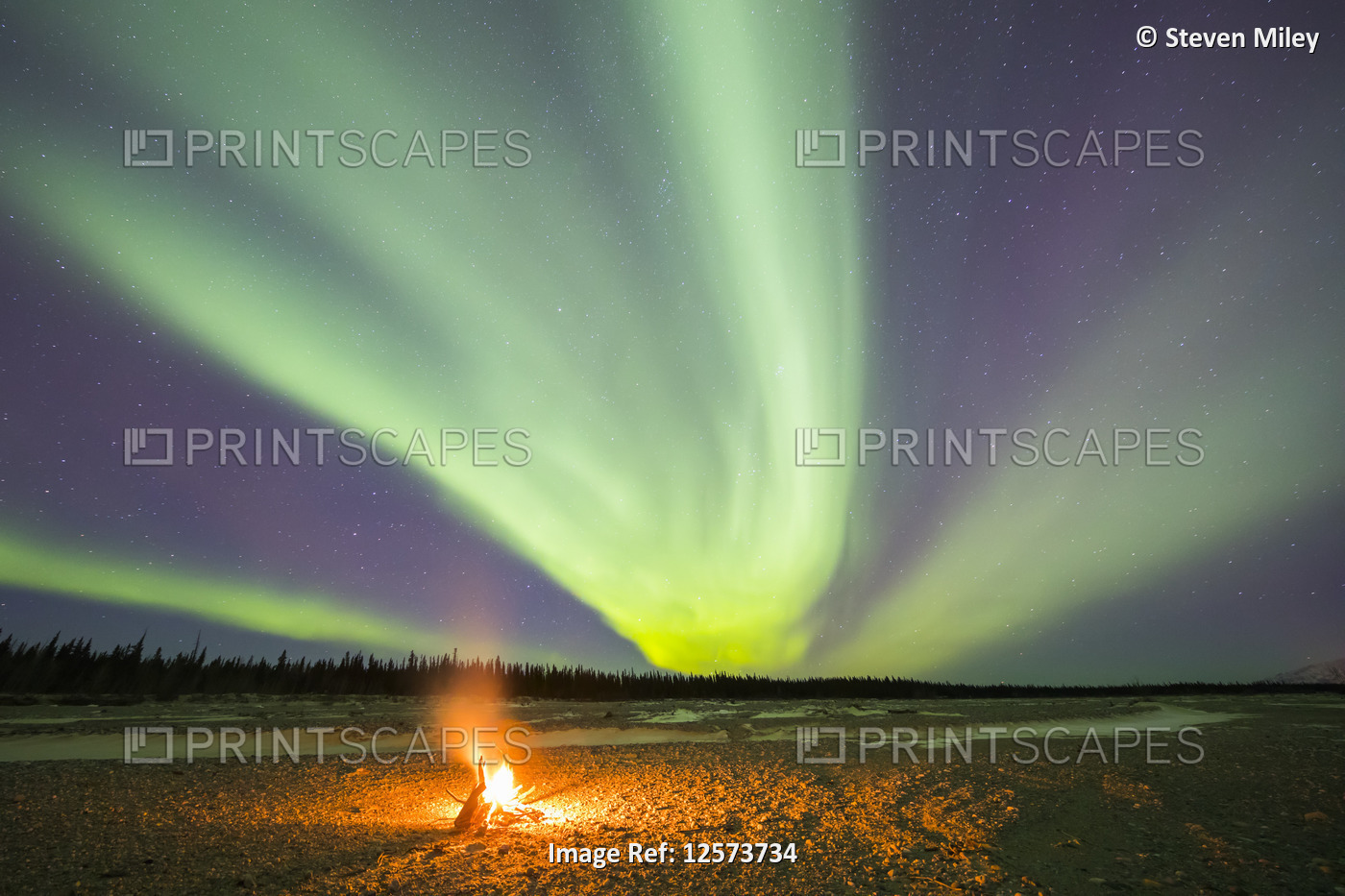 Aurora borealis above a campfire on Jarvis Creek in Delta Junction; Alaska, ...