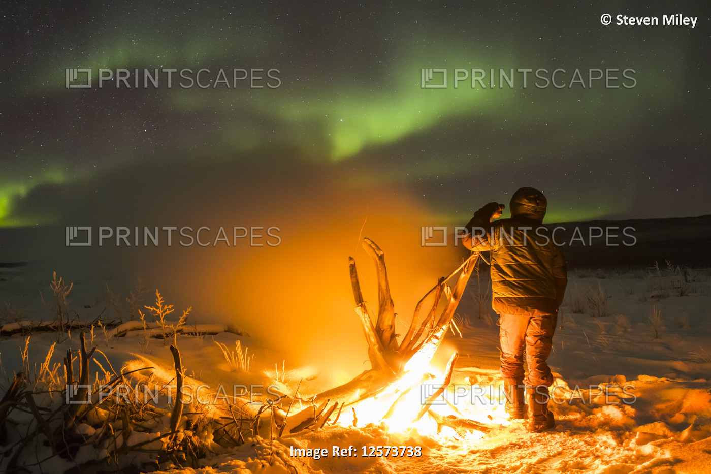 Staying warm beside a campfire on the Delta River while watching the aurora ...