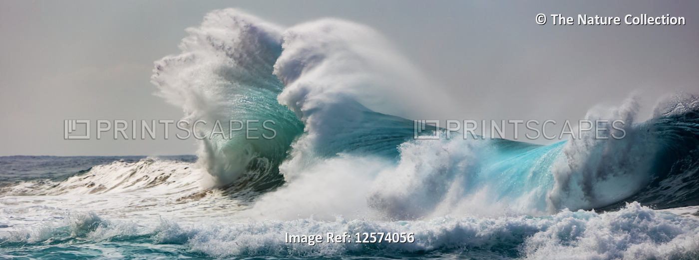Ocean waves crashing into the shore off the Na Pali coast; Kauai, Hawaii, ...