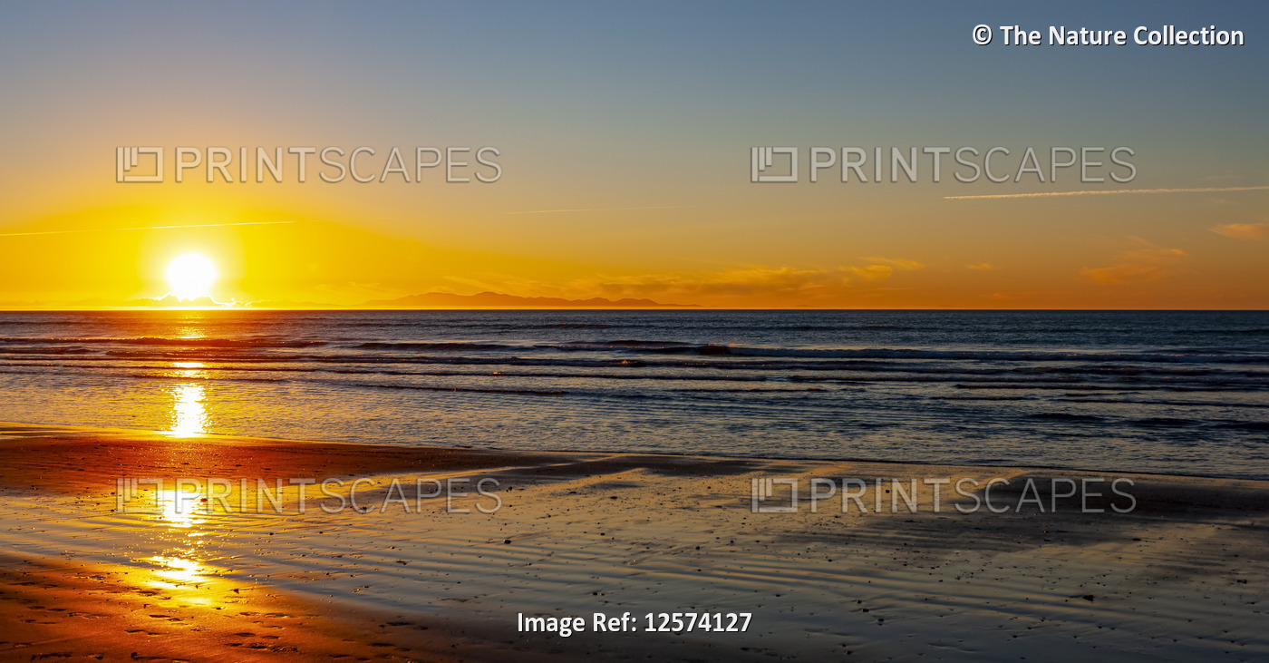 Bright sunset over the ocean off the North shore of New Zealand; North Island, ...