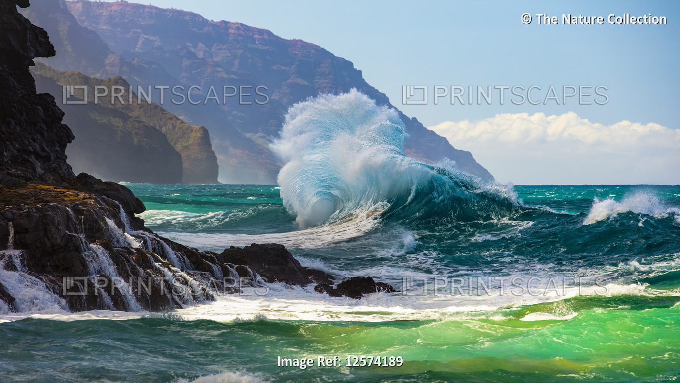 Large ocean wave crashes into rock along the Na Pali Coast; Kauai, Hawaii, ...