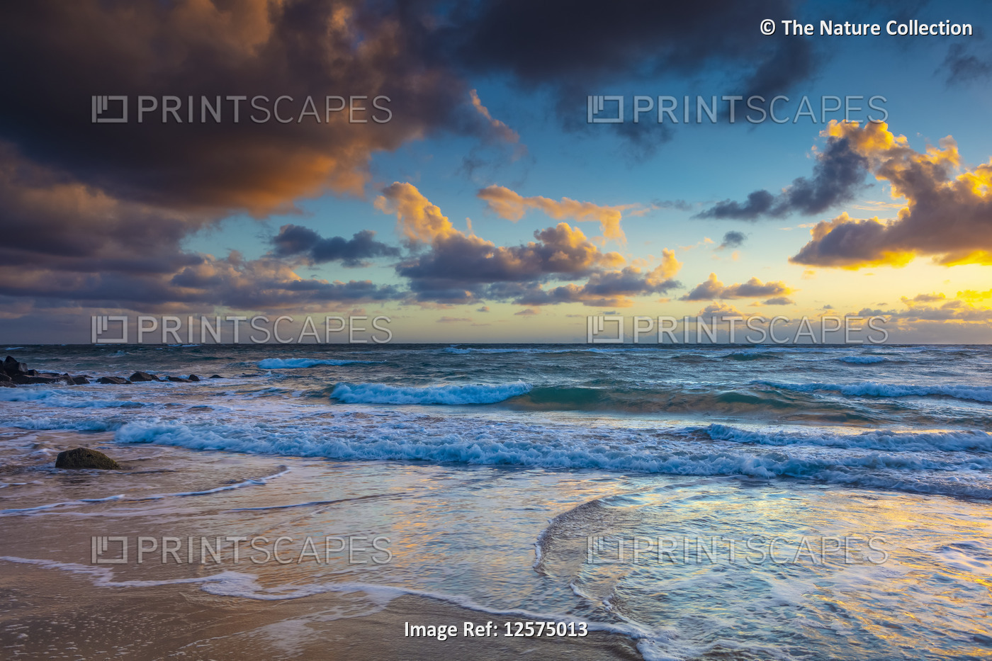 Sunrise over beach and ocean with tide washing up over sand; Kauai, Hawaii, ...