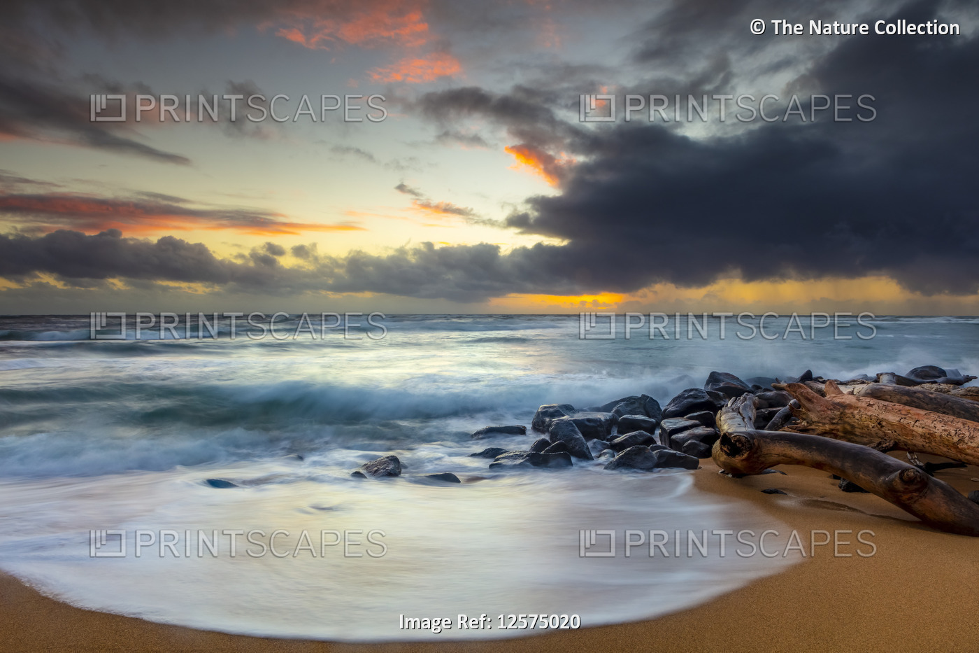 Sunrise over beach and ocean with a storm cloud and rain in the distance; ...