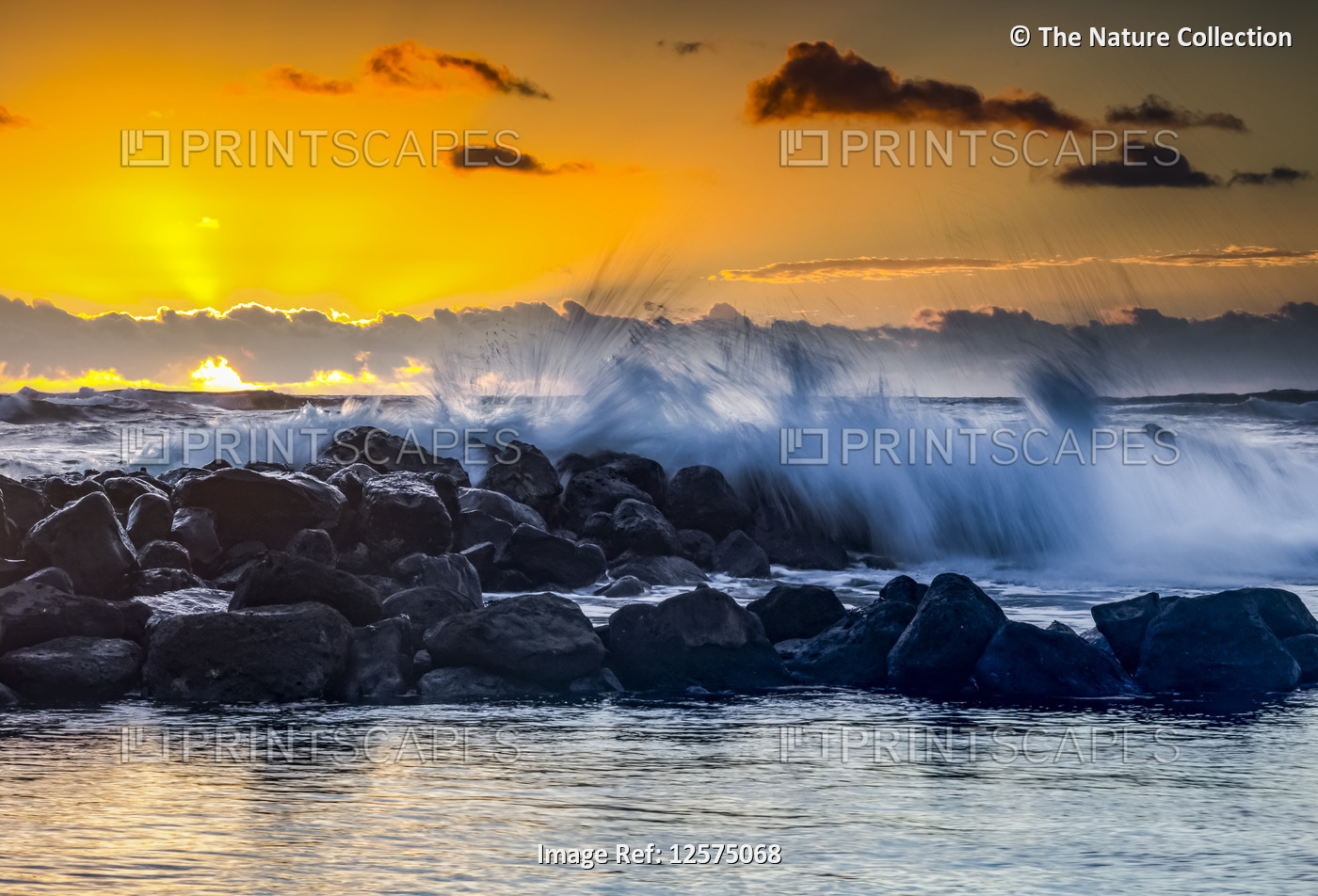 Golden sunrise over Lydgate Park and the ocean from the coast of Kauai with a ...