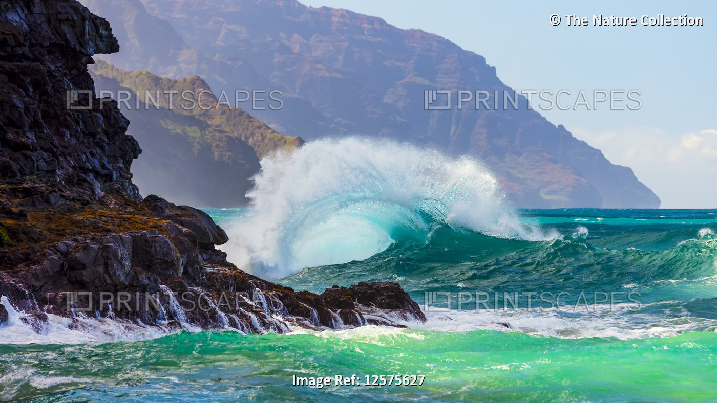 Large waves crash into the Na Pali coastline at Ke'e Beach; Kauai, Hawaii, ...