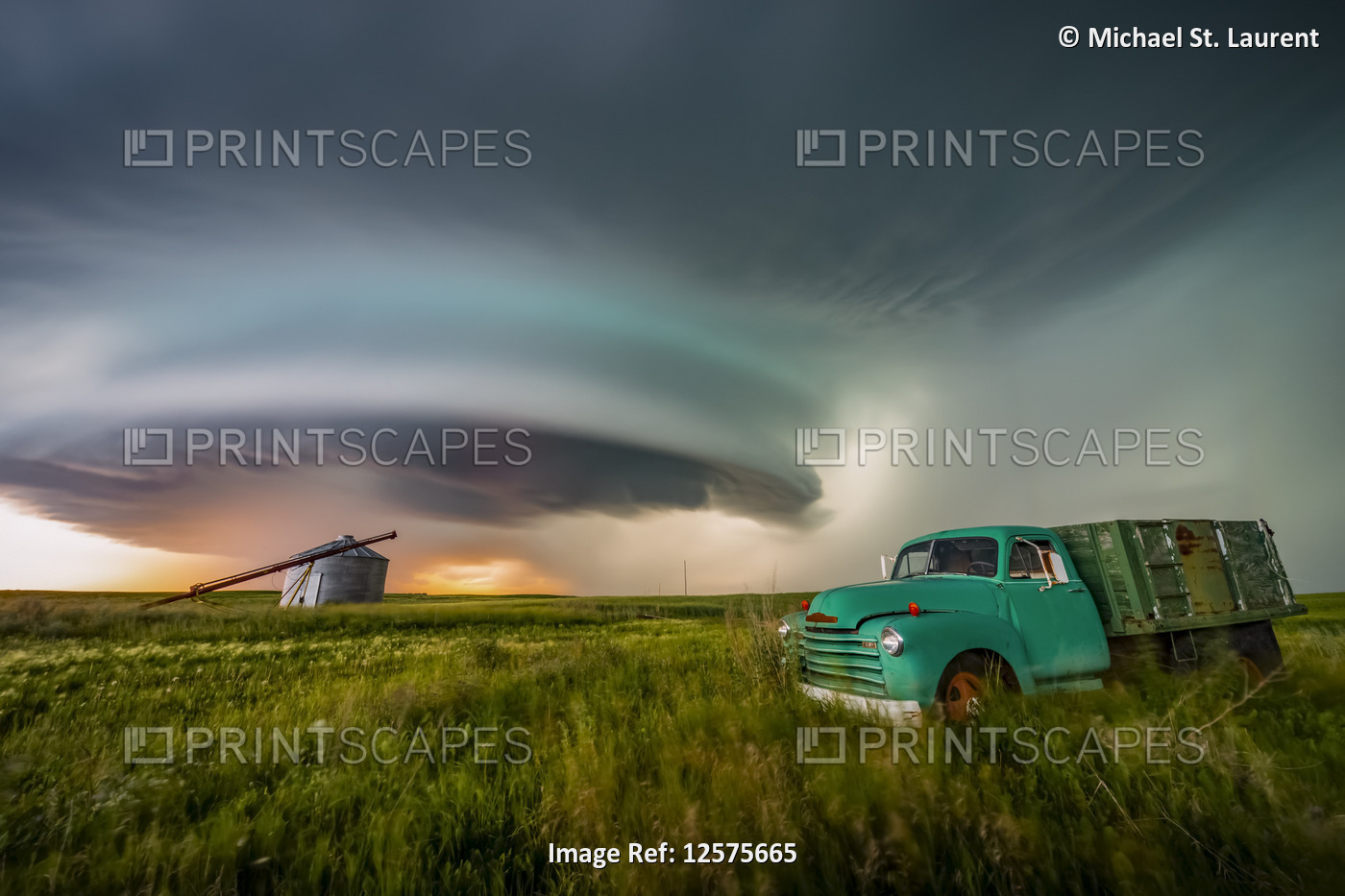 Vintage truck on farmland under a dramatic stormy sky; Moose Jaw, Saskatchewan, ...