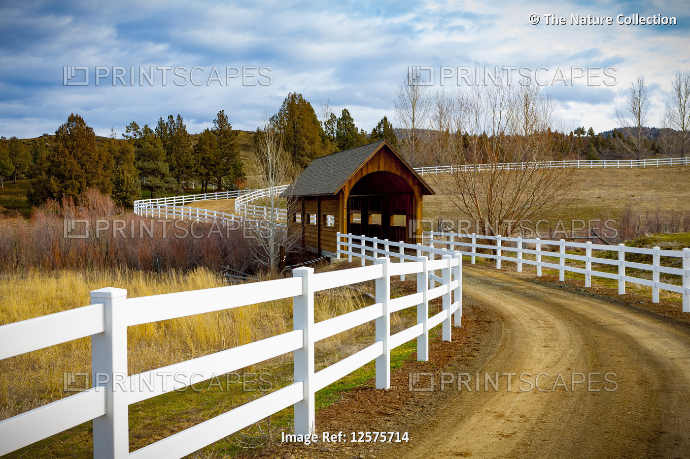 Covered bridge over a river in the countryside with dirt road; Oregon, United ...
