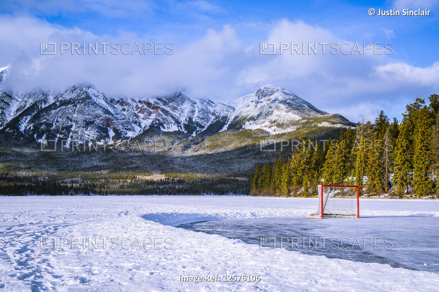 Frozen Pyramid Lake with hockey net on a cleared ice rink in winter, Jasper ...