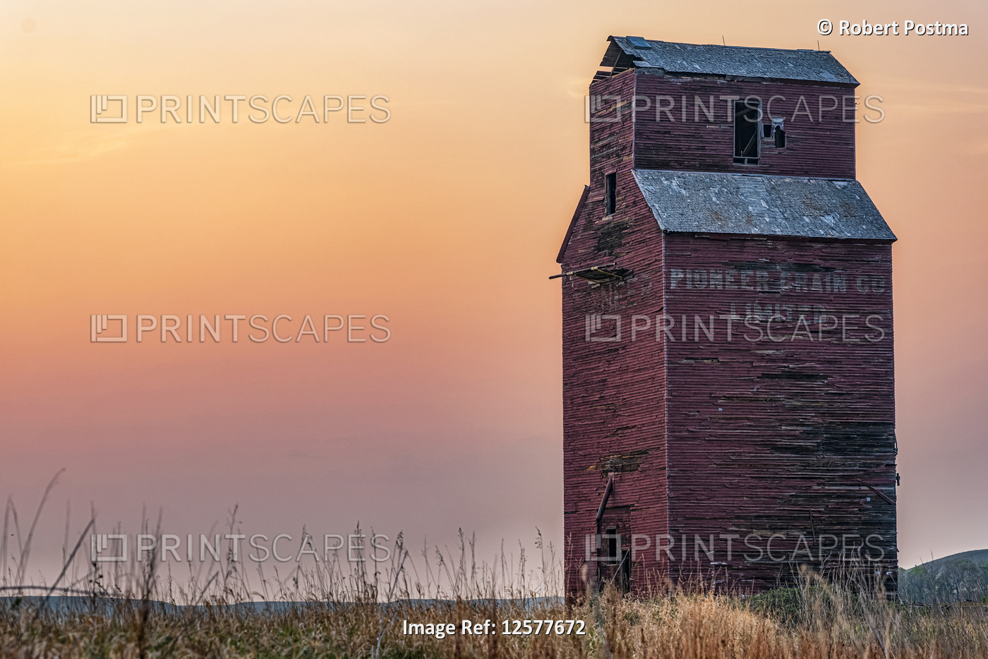 Abandoned and weathered grain elevator at sunset on the Canadian Prairies; Val ...