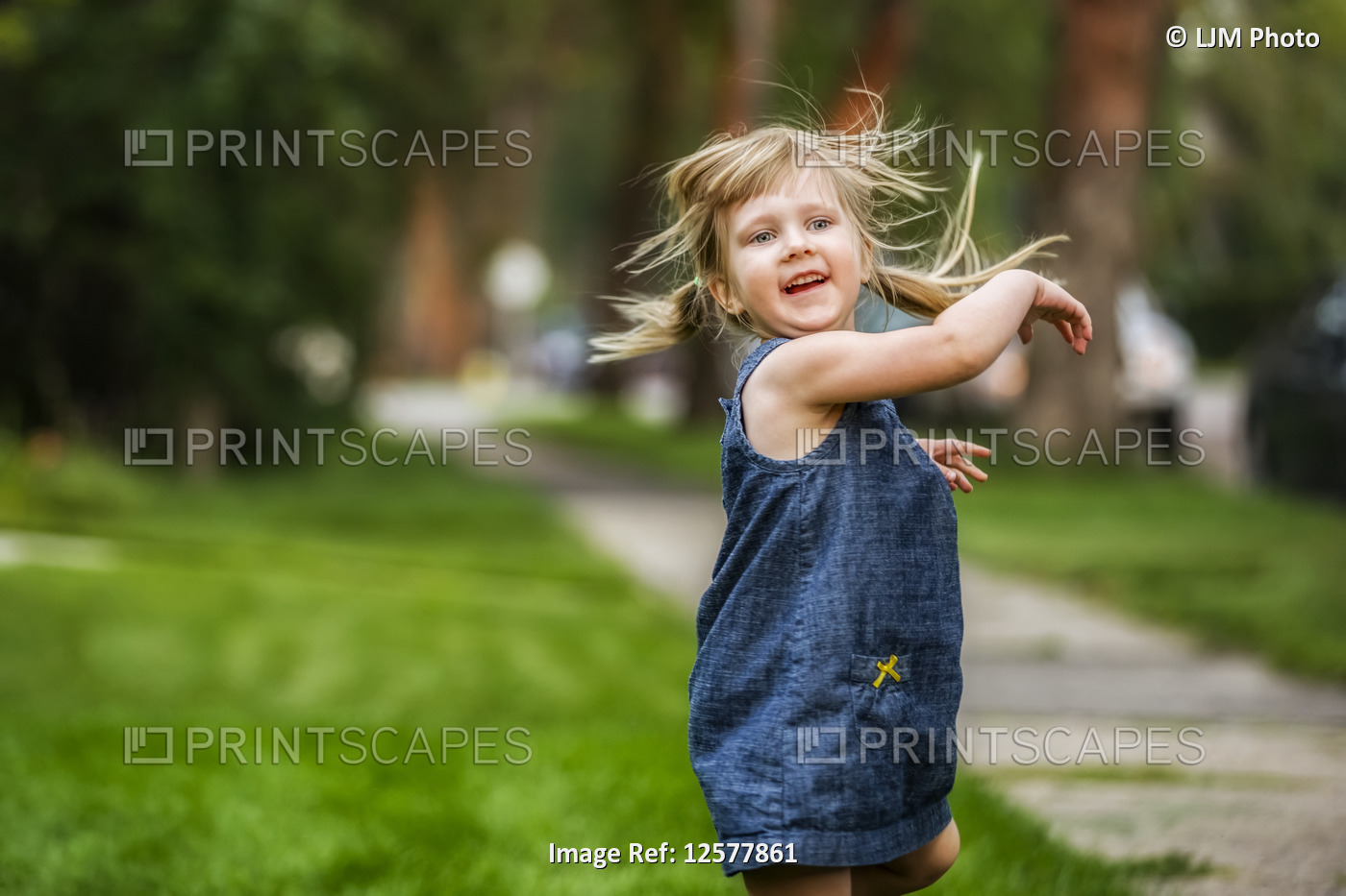 Young girl in pigtails moves during playtime in her neighbourhood; Edmonton, ...