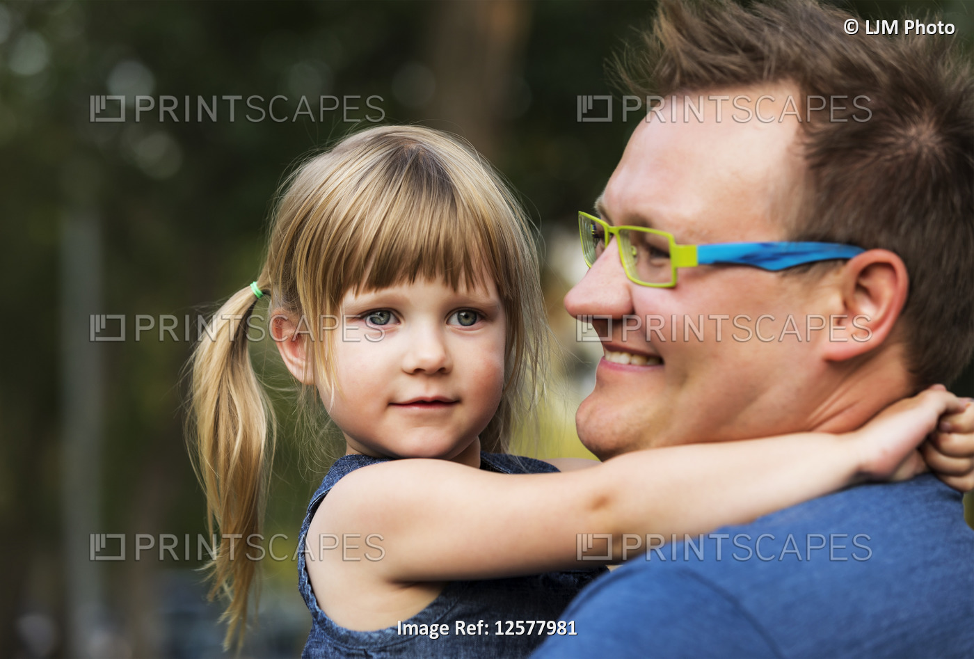 Portrait of a father cuddling with his young daughter; Edmonton, Alberta, Canada