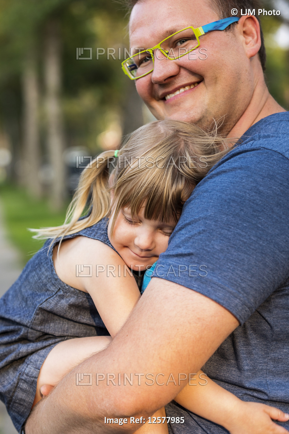 Portrait of a father cuddling with his young daughter; Edmonton, Alberta, Canada