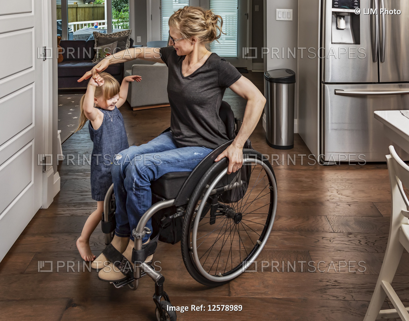 A paraplegic mother dancing with her daughter in the kitchen using her ...