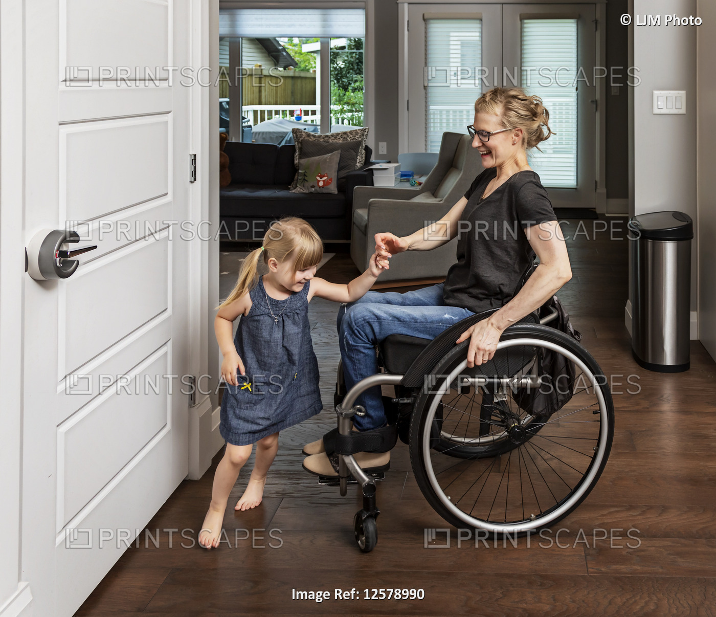 A paraplegic mother dancing with her daughter in the kitchen using her ...
