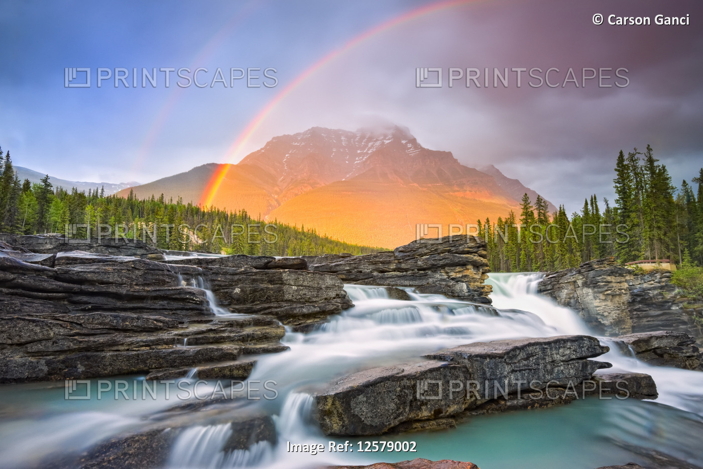 Double rainbow shining over a rugged waterfall and the Rocky Mountains, Jasper ...