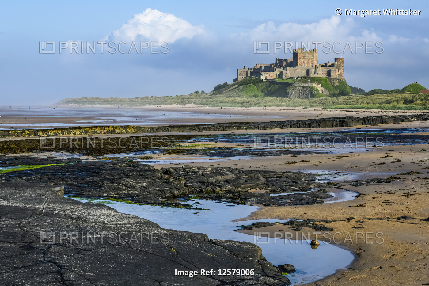 Bamburgh Castle with the tide out showing rocky coastline; Bamburgh, ...