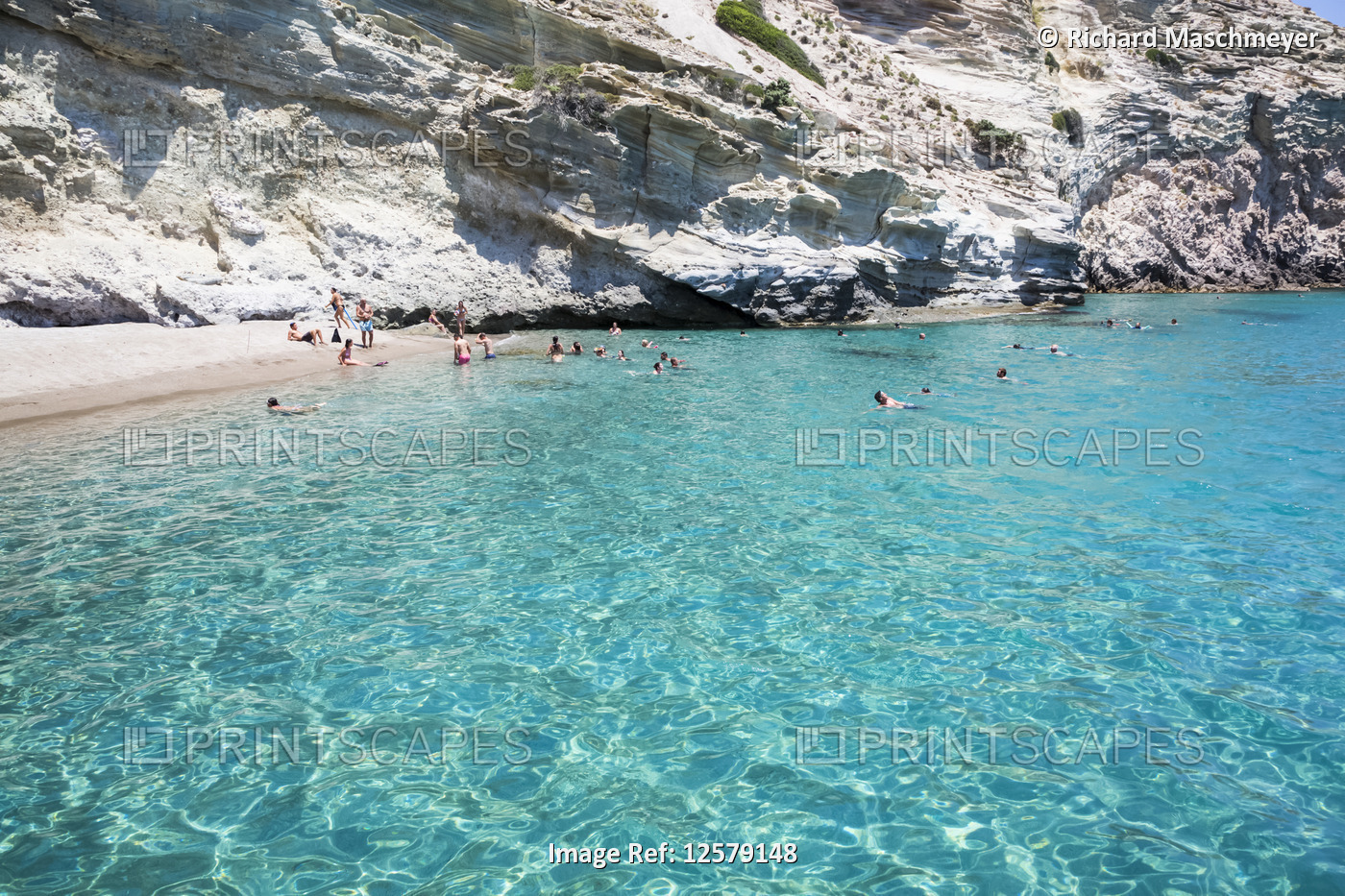 Tourists swimming in the clear, turquoise water of Galazia Nera Bay; Polyaigos ...