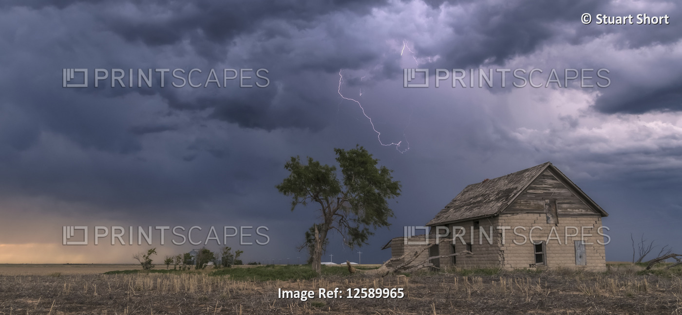 A forked lightning bolt descends from a weak thunderstorm near an abandoned ...