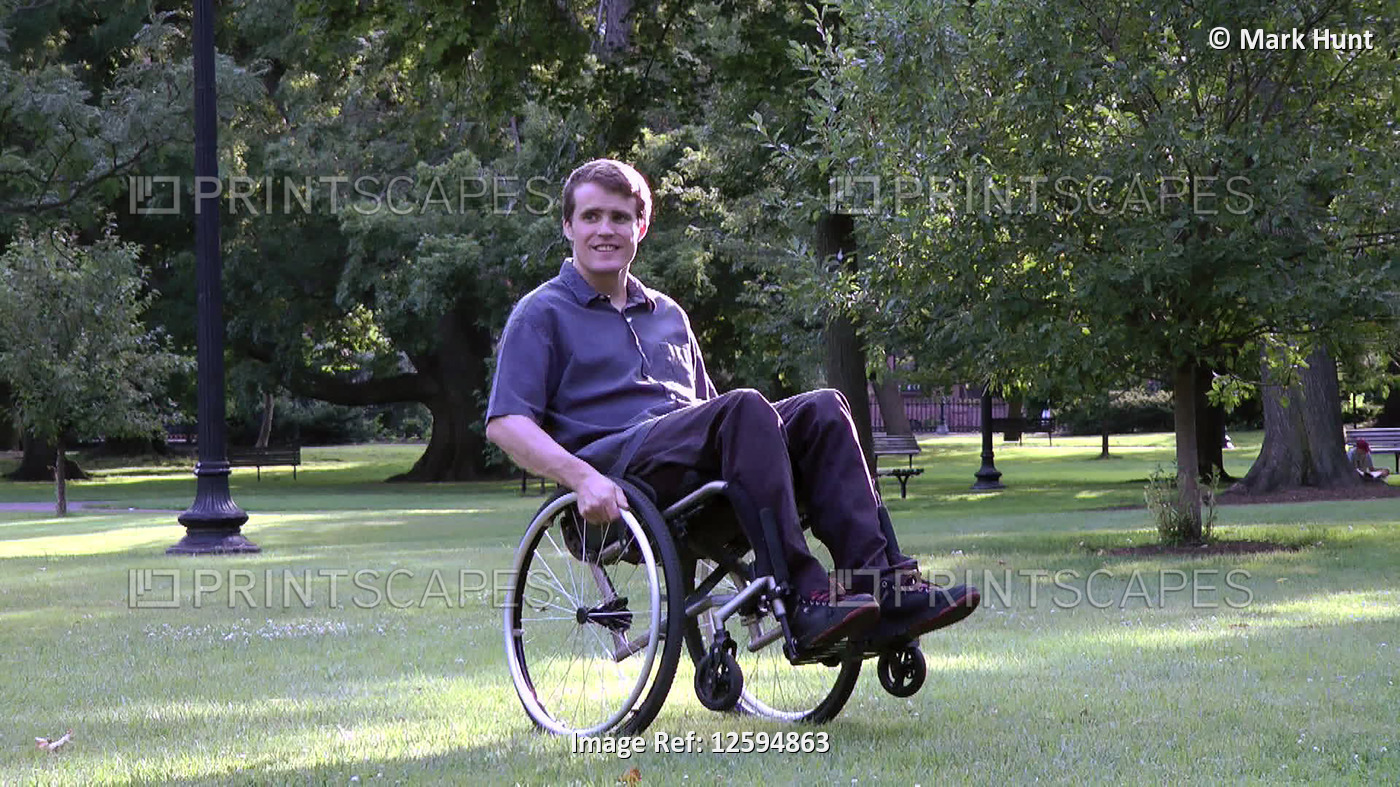 Man with spinal cord injury turning his wheelchair in a park; Massachusetts, ...