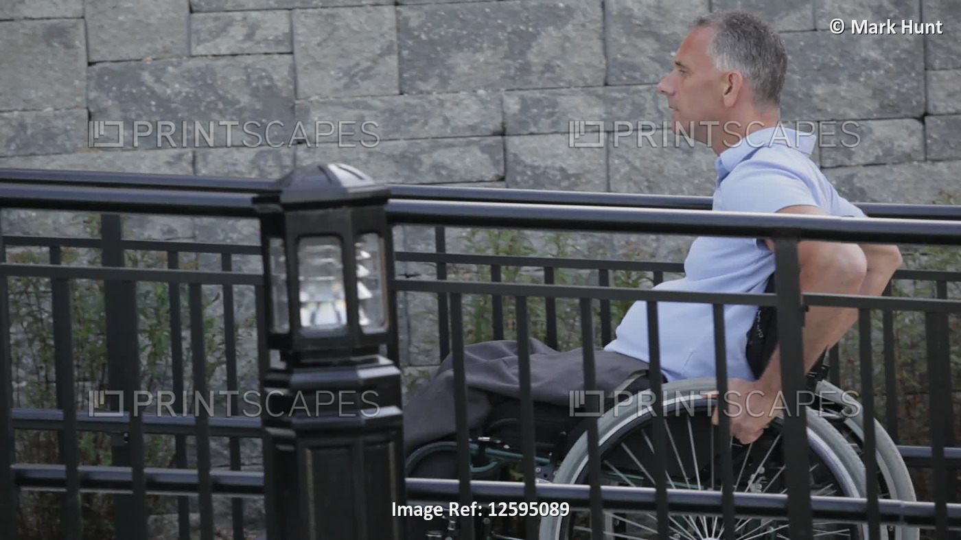 Man with spinal cord injury in a wheelchair using accessible wheelchair ramp ...