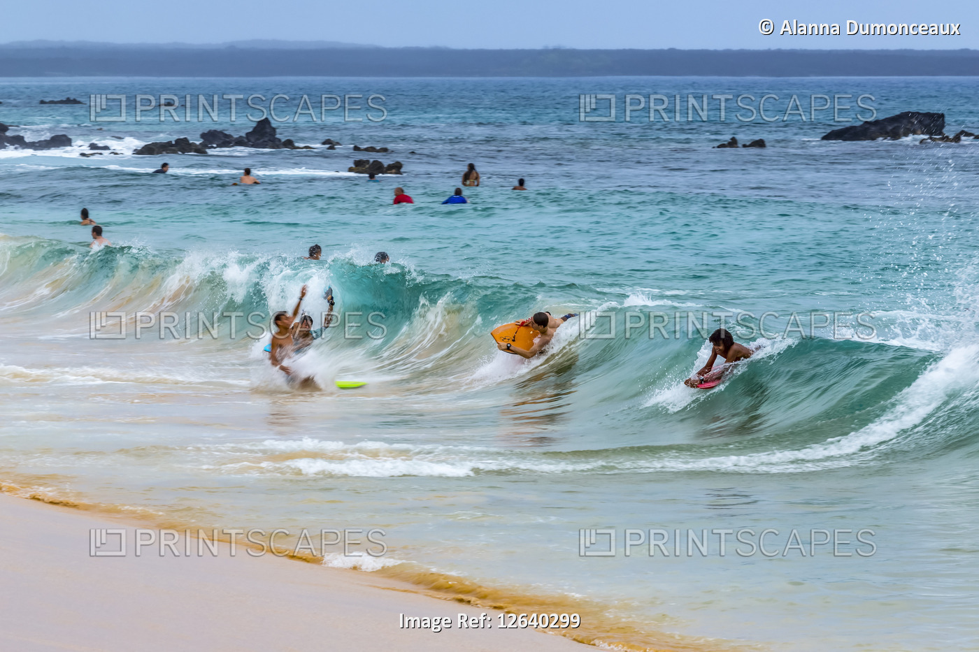 Surfers and body boarders play in the surf waves on Makena beach in on Maui, ...