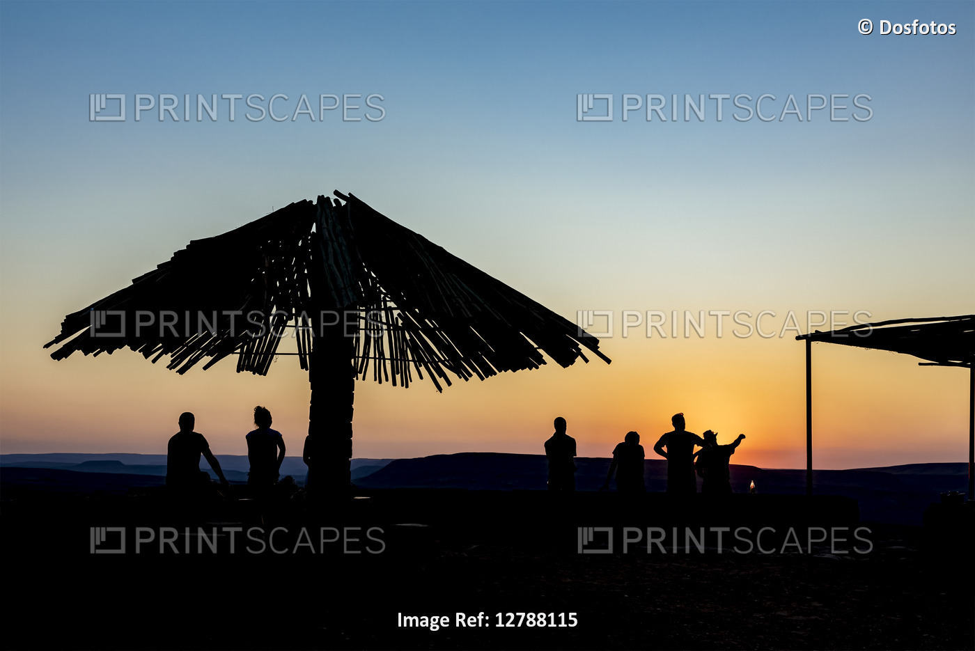 Silhouetted tourists and umbrella at sunset, looking out over Fish River ...