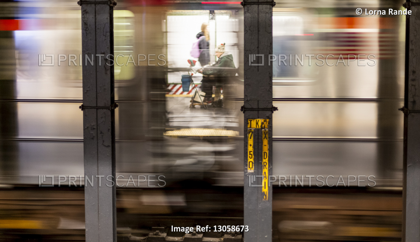 Senior man in scooter viewed through a subway window with the blur from the ...