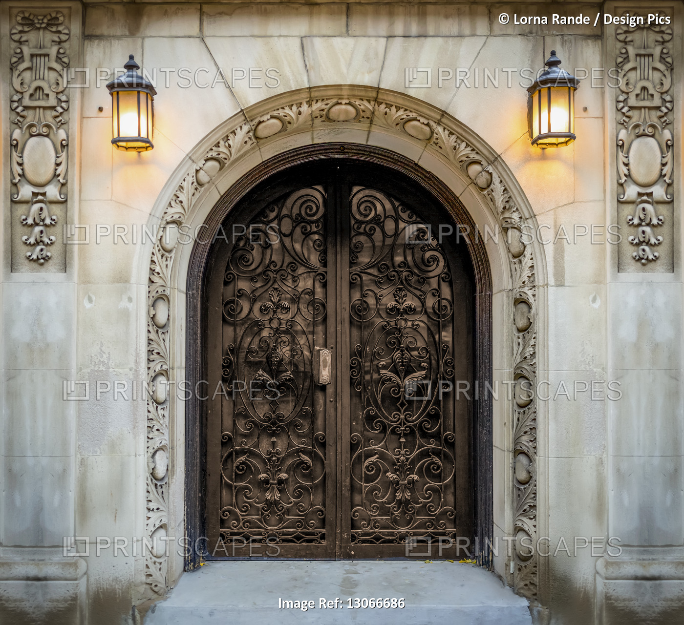 Ornate double doors with decorative carvings on the walls and mounted lit ...