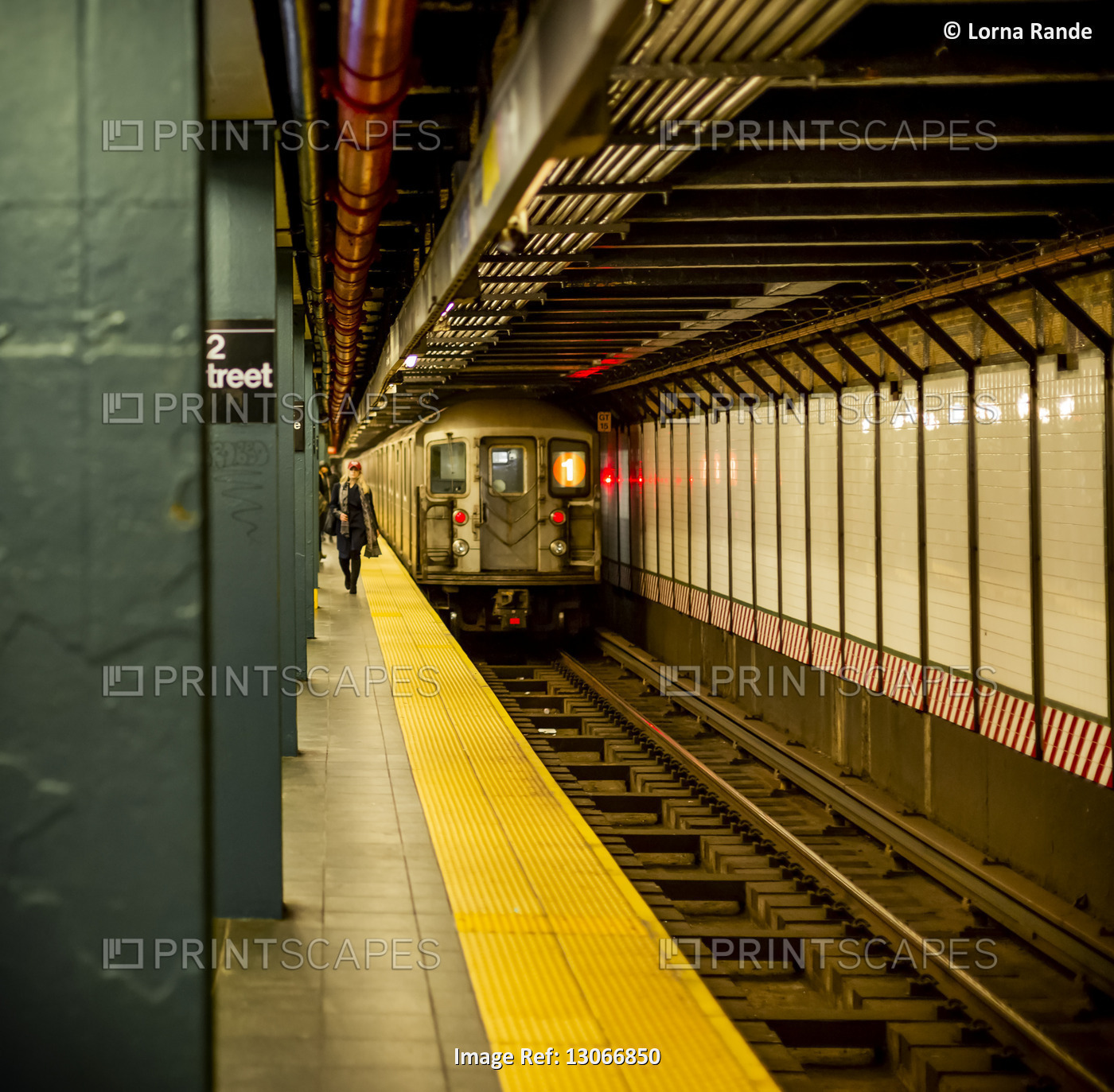 Underground subway on tracks with people walking on platform; New York City, ...