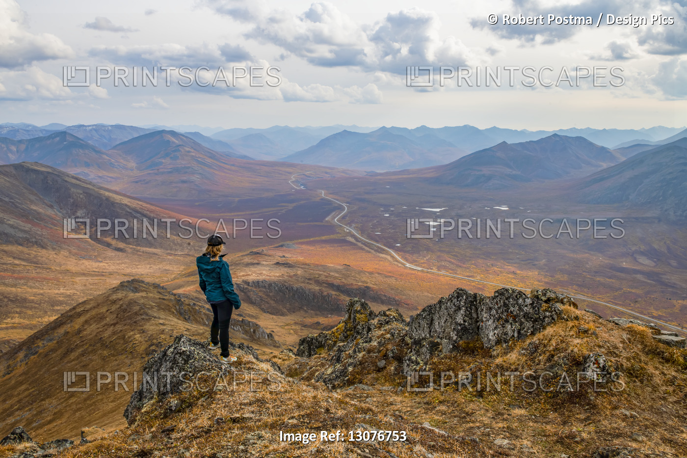 Woman exploring the mountains along the Dempster Highway during autumn in the ...