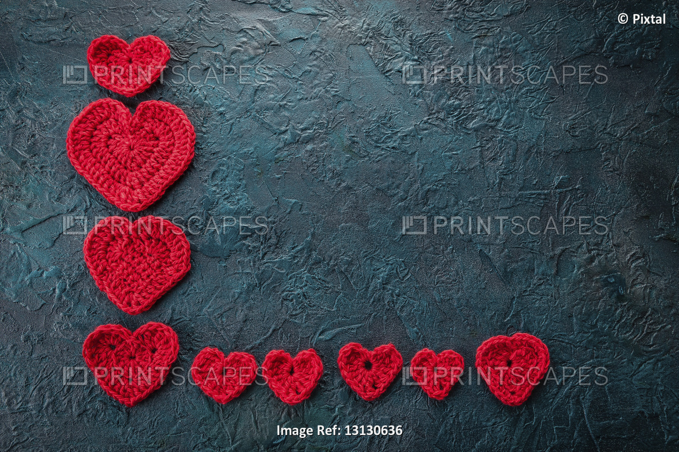 Red crochet valentine hearts on dark background.