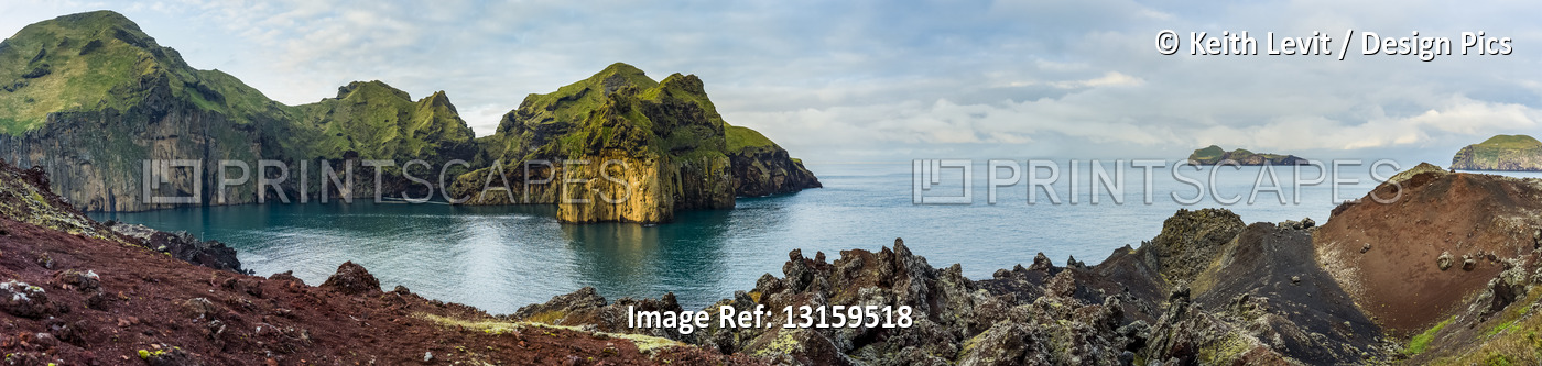 Rugged rock and cliffs along the coastline of the island of Heimaey, a part of ...